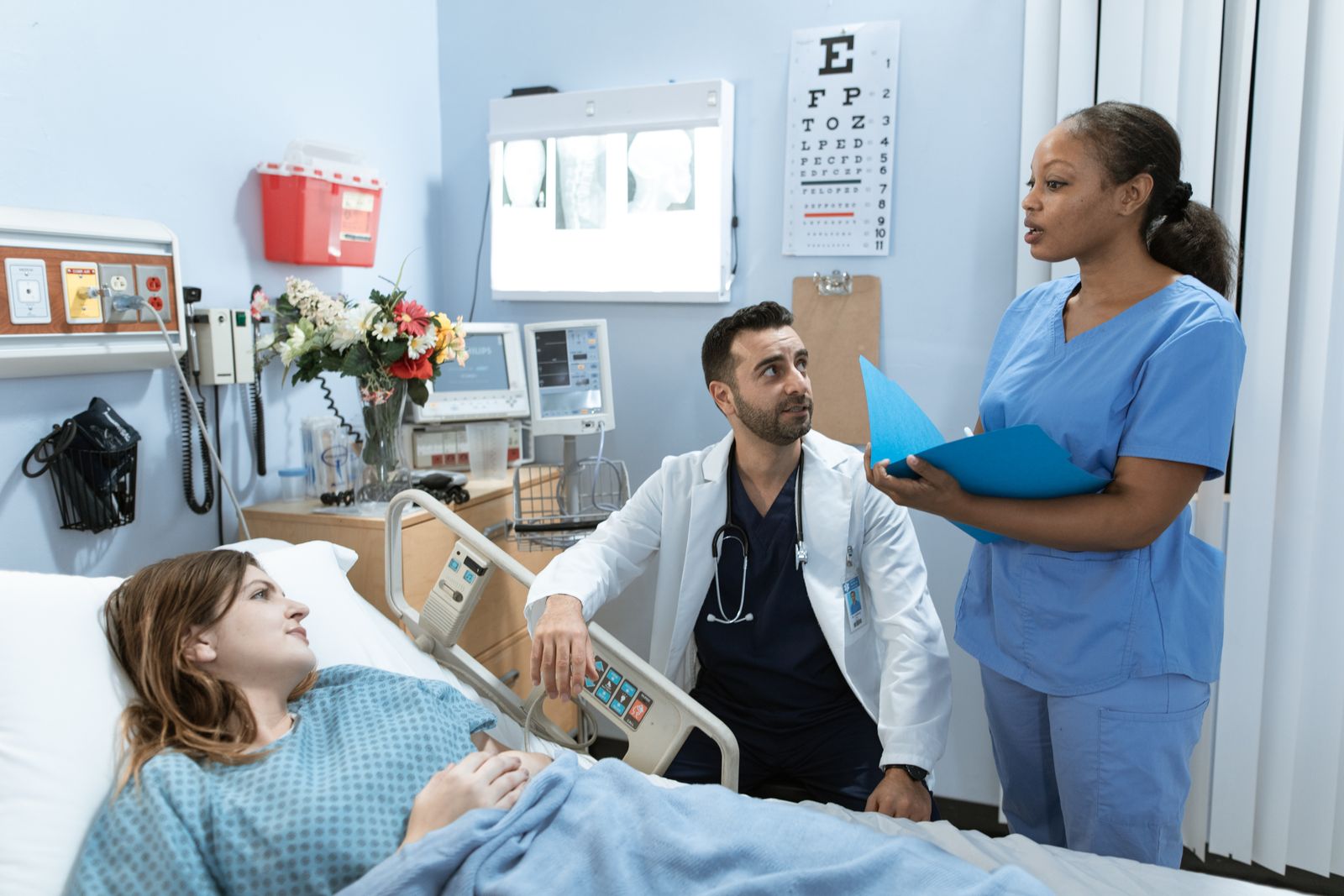 Doctor and nurse attending to a patient in a hospital room