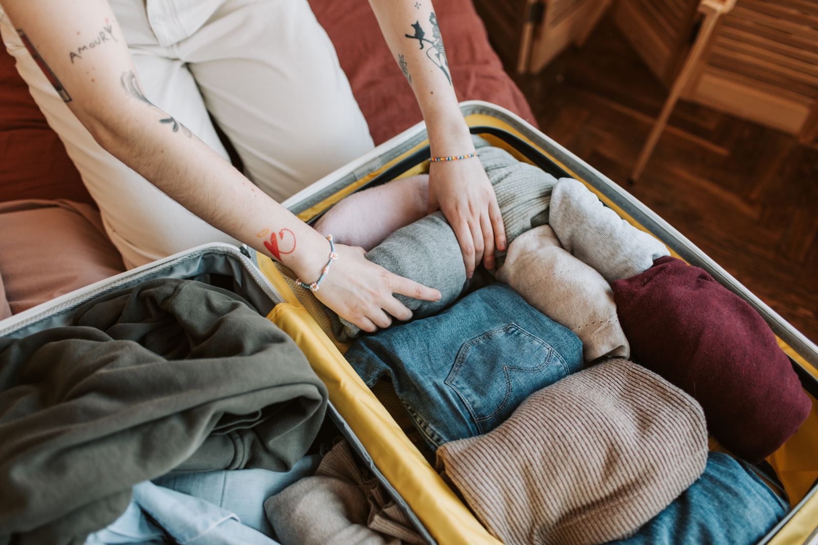 Traveller packing clothes and essentials into a suitcase