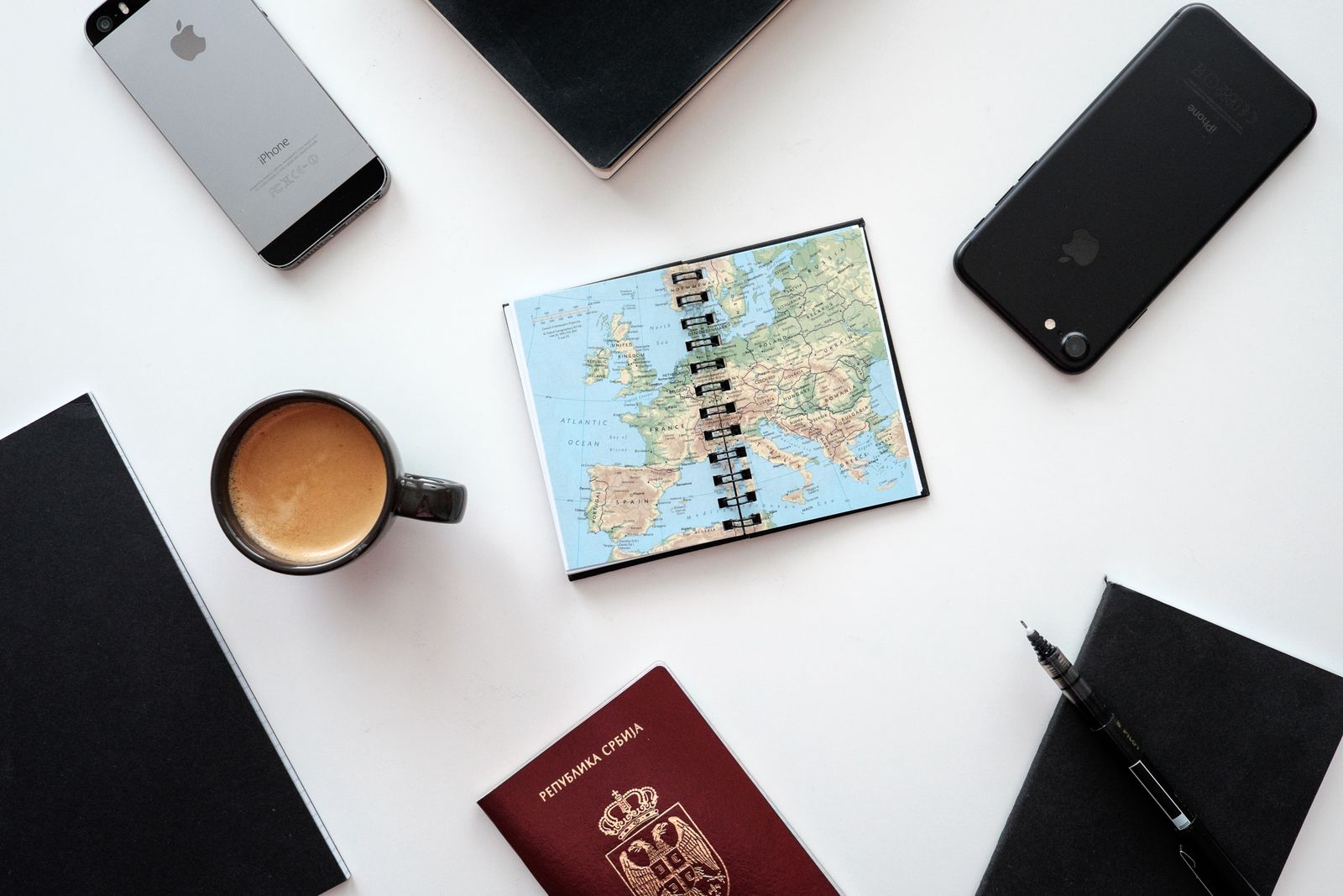 Travel planning flatlay with a map, notebook and coffee