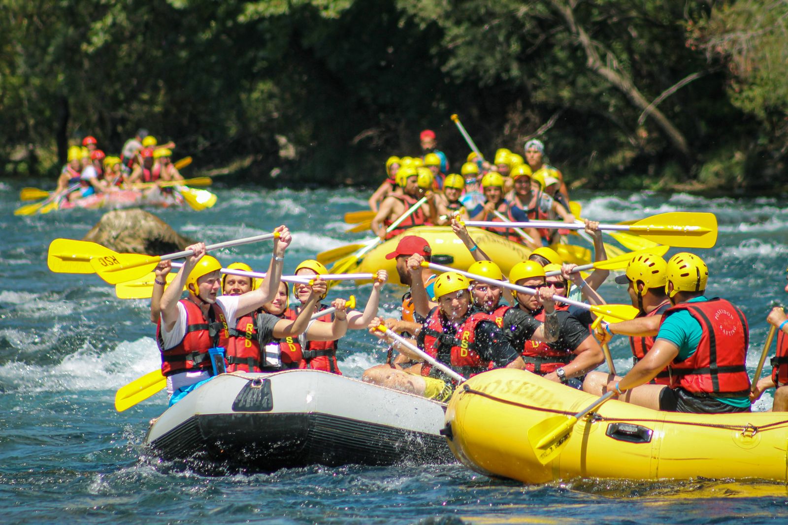 Group white water rafting through the rapids
